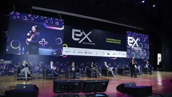 Painel com cinco líderes globais durante o evento Experience Expo 2025 em São Paulo, destacando discussões sobre experiências que movem negócios.