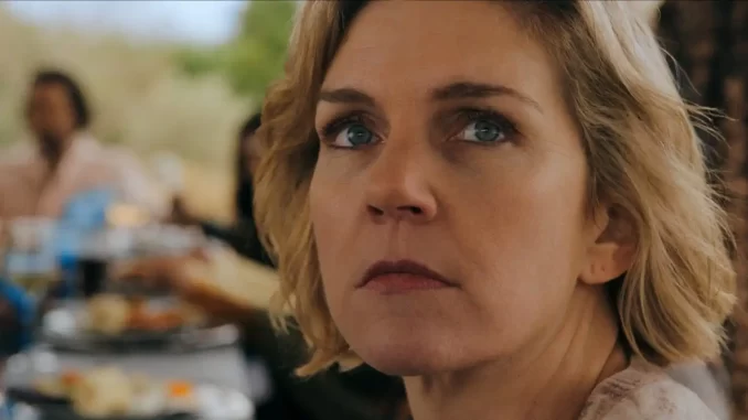 pluribus-episodio6-data-horario-trama Imagem de uma mulher com expressão séria, cena do episódio 6 de Pluribus, destacando data, horário e o que esperar da trama.