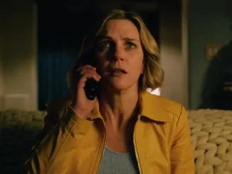 Cena da série Pluribus, nova produção de Vince Gilligan, mostrando uma mulher com cabelo castanho médio, usando jaqueta amarela, falando ao telefone em um ambiente doméstico.