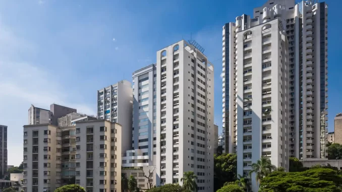 Imagens de prédios residenciais altos na cidade com céu azul ao fundo, representando o impacto do recuo do IGP-M de 0,11% em 12 meses no reajuste de aluguel.