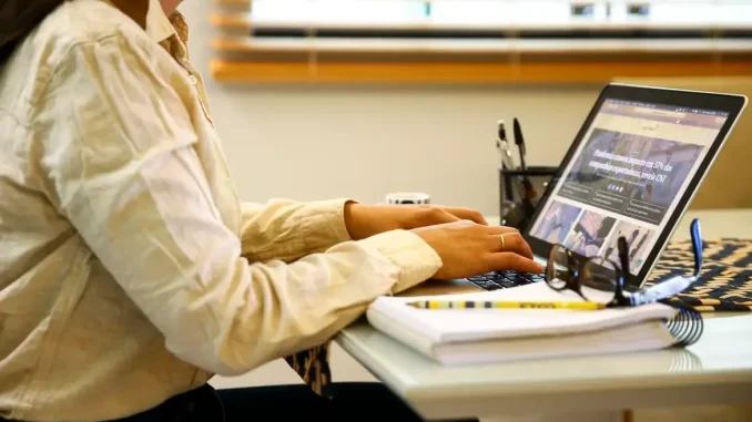 proporcao-trabalhadores-home-office-ibge Pessoa trabalhando em home office com laptop em uma mesa de escritório, representando a redução na proporção de trabalhadores em home office, que caiu a 7,9%, conforme mostra o IBGE.