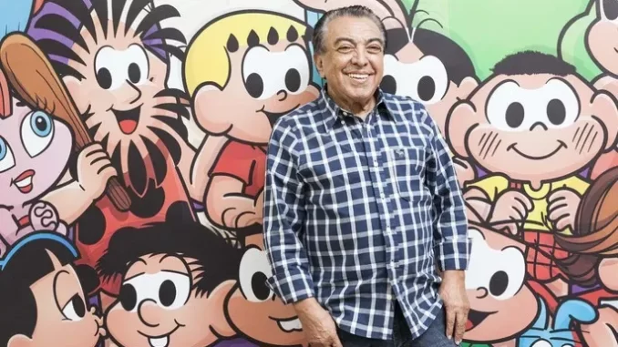 saopaulo-declara-obra-mauricio-de-sousa-patrimonio-cultural Homem sorridente ao lado de personagens clássicos de Maurício de Sousa, comemorando a declaração de São Paulo que reconhece suas obras como patrimônio cultural.