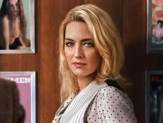 Cena da série italiana Sra. Playmen chegando à Netflix em 12 de novembro, com uma mulher com cabelo loiro e expressão séria em ambiente interno.