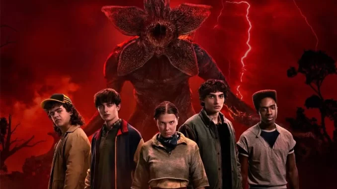 Cena de Stranger Things 5 com personagens principais e uma criatura assustadora ao fundo sob céu avermelhado e raios, fãs especulam seis mortes no final.