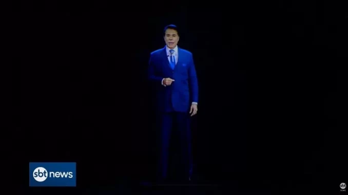 Imagem de um apresentador em um palco, vestido formalmente com terno azul, durante uma transmissão ao vivo do SBT News, com fundo preto.