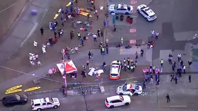 atentado-em-evento-judaico-em-sydney-australia Imagem aérea de um ataque durante evento judaico em Sydney na Austrália, com várias vítimas e equipes de emergência atuando após o atentado que deixou 12 mortos.