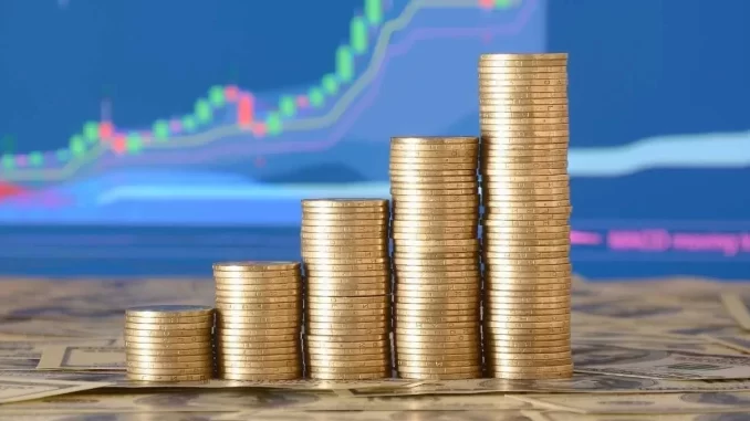 Gráfico financeiro mostrando crescimento de lucros representados por pilhas de moedas em aumento, com fundo de tela com dados econômicos. Destaca a melhora na economia brasileira com Boletim Focus elevando o PIB para 2,25% e controlando a inflação em 4,40%.