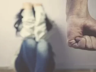 Imagem que representa a preocupação com o aumento dos feminicídios na capital paulista, que bate recorde em 2025 até outubro, com destaque para uma mão fechada em sinal de ameaça e uma mulher ao fundo