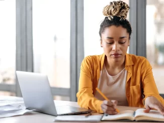 Jovem estudante revisa materiais de estudo para vestibular em ambiente tranquilo, buscando apoio emocional e estratégias para reduzir a pressão durante a preparação.