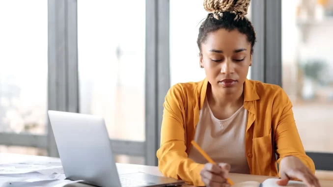 Jovem estudante revisa materiais de estudo para vestibular em ambiente tranquilo, buscando apoio emocional e estratégias para reduzir a pressão durante a preparação.