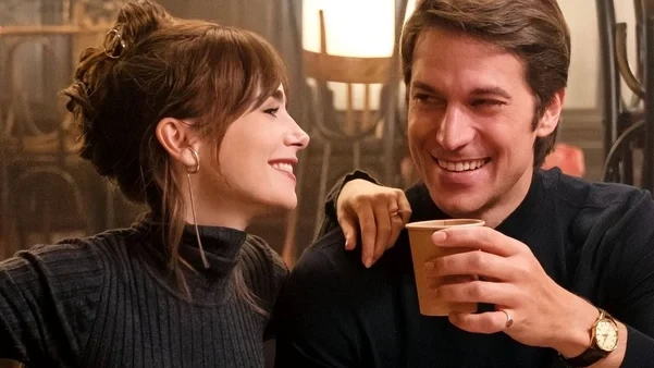 emily-em-paris-novo-rumo-para-gabriel-6a-temporada Cena de Emily em Paris apontando novo rumo para Gabriel na 6ª temporada, com personagens sorrindo e conversando em um ambiente acolhedor.