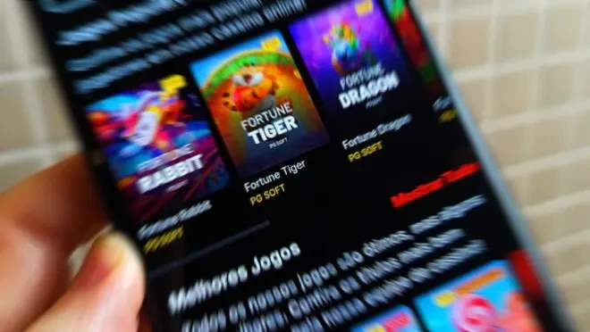 Tela de celular mostrando jogos de apostas online, incluindo Fortune Tiger e outros, relacionada ao estudo sobre o custo anual de R$ 38,8 bilhões no Brasil.
