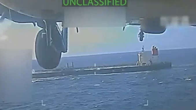 EUA levam petroleiro da Venezuela a porto americano para confisco, visto por drone na água, avião militar no fundo, operação militar em andamento.