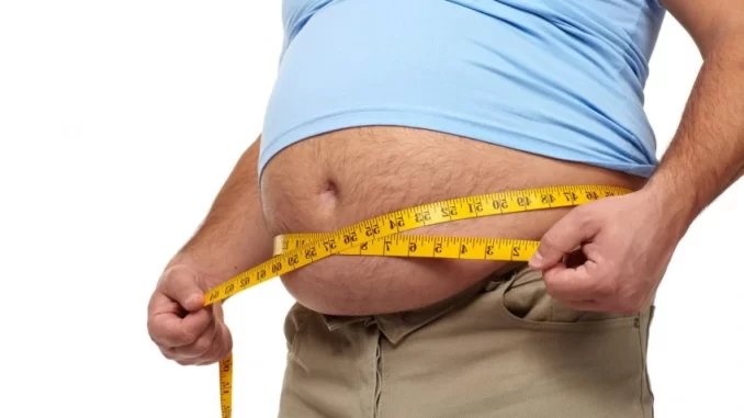 gorduraprofundadaimpactoestruturacardiaca-jpg Homem medindo a gordura abdominal com fita métrica, destacando a importância da gordura abdominal na saúde do coração.