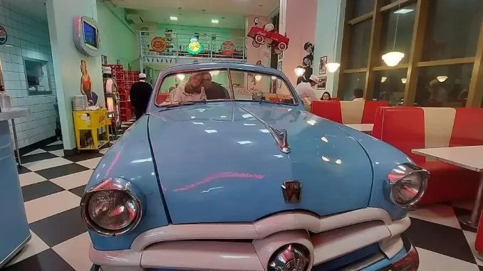 hamburgueriaretrostrangerthingssp-jpg Hamburgueria retrô em SP com clima de Stranger Things dos anos 80, decoração vintage com carro antigo no ambiente.