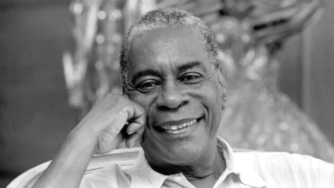 haroldo-costa-95-anos-samba-jornalismo Imagem de Haroldo Costa aos 95 anos, referência do samba e do jornalismo, sorrindo em foto preta e branca, destacando sua trajetória e legado cultural.