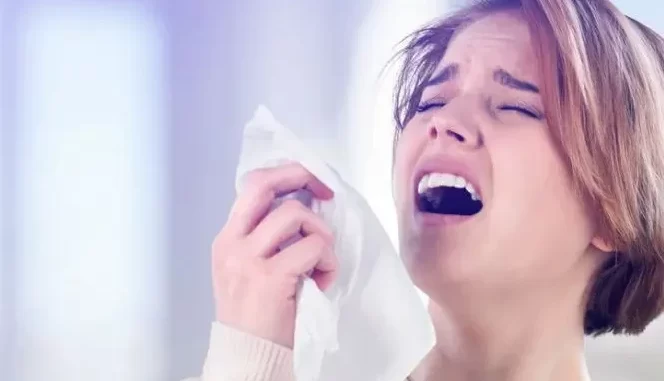 luz-forte-provoca-espirro-reflexo-genetico-raro Mulher com rosto de desconforto ao espirrar devido ao reflexo genético raro de luz forte que provoca espirro em algumas pessoas