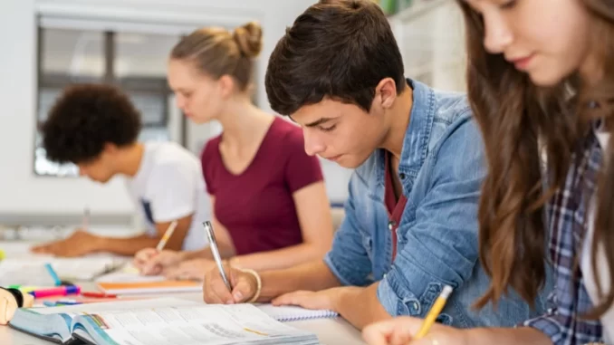 Estudantes em sala de aula estudando para o ensino integral, alinhado à meta do MEC de ampliar o ensino integral em todo o Brasil até 2026.