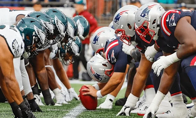 NFL leva a Super Bowl LX Experience para sete países, incluindo Brasil, com jogadores de futebol americano em ação na linha de scrimmage.
