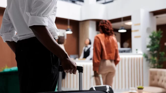 novas-regras-checkin-checkout-hoteis-vigor Hóspedes de hotel com malas no saguão, símbolo das novas regras de check-in e check-out em vigor, facilitando o processo de entrada e saída dos hóspedes.