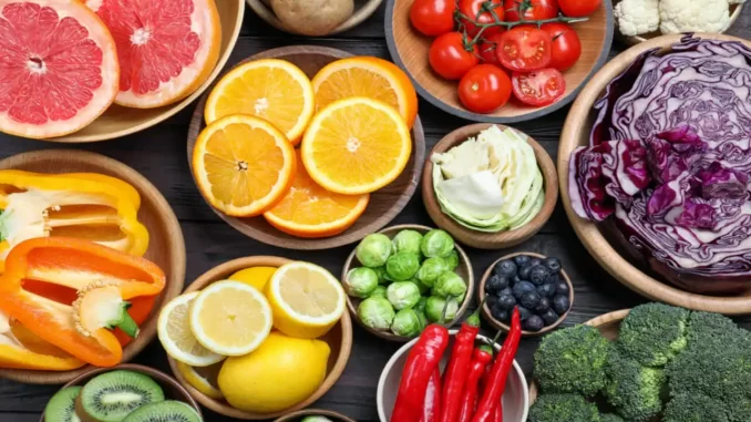 Variedade de alimentos ricos em vitamina C, incluindo frutas cítricas, tomates, brócolis, pimentões, e folhas verdes, que fortalecem a imunidade.