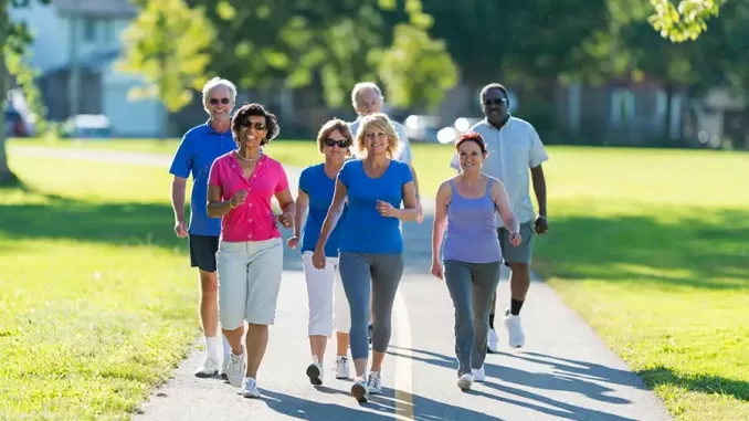 pessoas-idosas-caminhando-saude-natal Grupo de pessoas idosas caminhando ao ar livre, praticando exercícios para proteger o coração neste Natal, com recomendações médicas de menos álcool e mais caminhada.