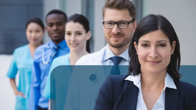 portaria-autoriza-transferencia-servidor-risco-de-violencia Grupo de servidores públicos aguardando para receber autorização de transferência devido a risco de violência grave, relacionado à portaria. Mulheres e homens na fila de atendimento.