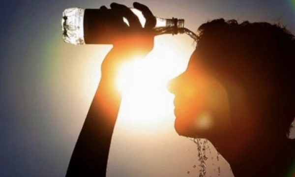 prevencao-doencas-verao-calor-intenso Pessoa se hidratando com água para prevenir doenças causadas pelo calor intenso no verão, como desidratação e insolação.