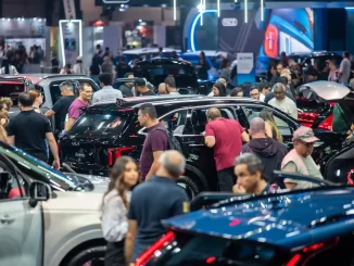Pessoas explorando diversos carros no Salão do Automóvel, que recebeu 516 mil visitantes e retornará em 2027, em uma grande exposição automotiva.