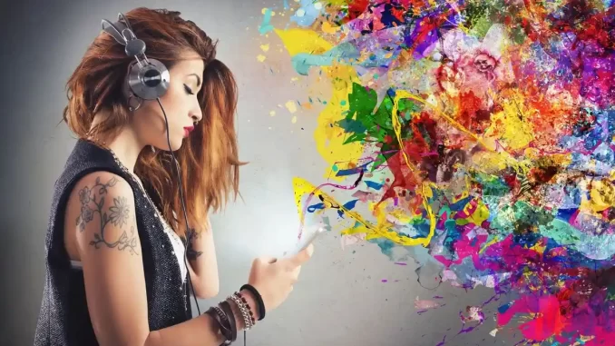 Jovem mulher ouvindo música com fones de ouvido enquanto transforma luzes coloridas e formas abstratas em uma explosão de cores, ilustrando a sinestesia potencializando a memória e facilitando a aprendizagem de novos idiomas.