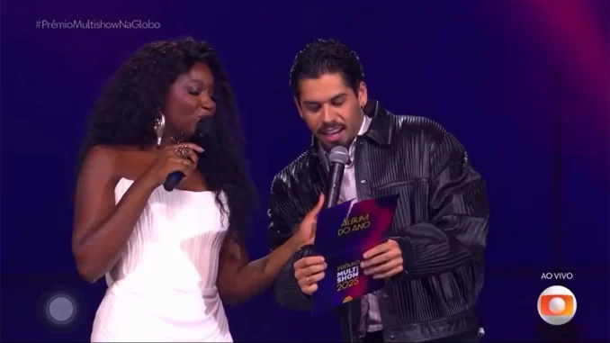 ze-felipe-explica-confusao-com-nome-dominguinhos-premio-multishow Zé Felipe explica confusão com nome de Dominguinhos durante o Prêmio Multishow, enquanto participa do evento ao lado de apresentadora.