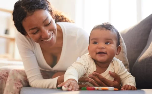 autocuidado-pos-parto-bem-estar-mae-bebe Mãe cuidando do bebê após o parto, simbolizando a importância do autocuidado no pós-parto para o bem-estar da mãe e do bebê.