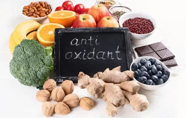 Imagem mostrando cinco alimentos antioxidantes populares como nozes, gengibre, frutas cítricas, mirtilos e brócolis, essenciais na dieta para combater radicais livres.