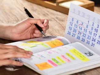 Jovem usando planner de papel para organizar suas tarefas, ilustrando o crescimento do uso de planners tradicionais entre os jovens devido à fadiga digital.