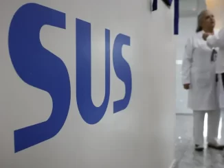 Imagem de profissionais de saúde conversando em hospital no Brasil, destacando a satisfação dos brasileiros com o SUS, que supera a média da América Latina, segundo pesquisa.