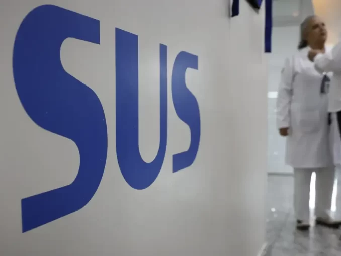 Imagem de profissionais de saúde conversando em hospital no Brasil, destacando a satisfação dos brasileiros com o SUS, que supera a média da América Latina, segundo pesquisa.