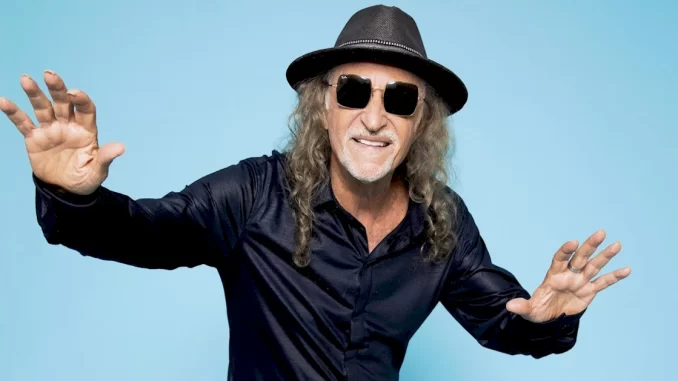 Alceu Valença durante a Turnê 80 Girassóis que chega a São Paulo no Villa-Lobos, vestindo chapéu, óculos escuros, camisa azul e cabelos longos e grisalhos