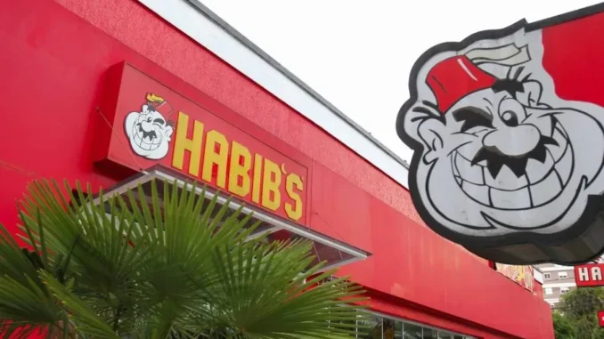 Fachada da rede Habib’s com o letreiro “HABIB’S” e o mascote do restaurante em destaque, em contexto de notícia sobre o Grupo Habib’s em recuperação judicial.