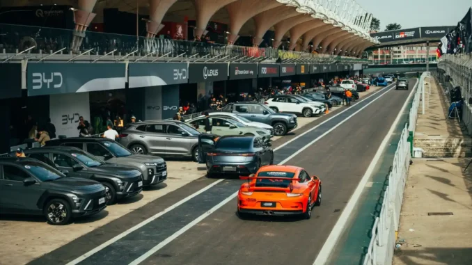 Festival Interlagos Auto 2026 em São Paulo: fila de carros e lançamentos em pista no autódromo, com público e veículos estacionados ao longo das arquibancadas.