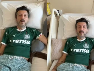 Influenciador Lito Souza em foto sentado em uma cama, usando camisa verde do Palmeiras, enquanto recebe cuidados; destaque para a discussão sobre a Doença de Creutzfeldt-Jakob e busca por tratamentos para condição rara.