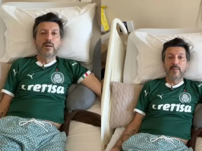 Influenciador Lito Souza em foto sentado em uma cama, usando camisa verde do Palmeiras, enquanto recebe cuidados; destaque para a discussão sobre a Doença de Creutzfeldt-Jakob e busca por tratamentos para condição rara.