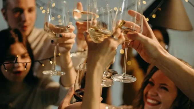 planejamento-antecipado-confraternizacao-corporativa-dezembro-brinde Planejamento antecipado em confraternização corporativa de dezembro, com pessoas brindando em uma festa festiva, taças de espumante e clima de celebração.